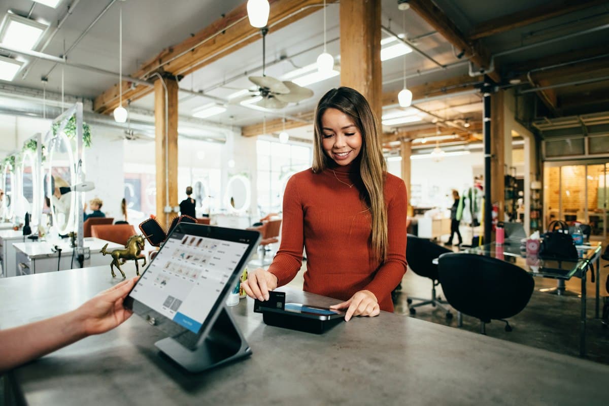 Nhân viên bán lẻ sử dụng máy POS tại cửa hàng